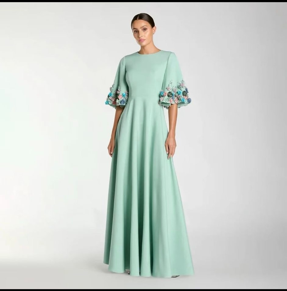 A flowing mint dress with delicate floral details on the sleeves